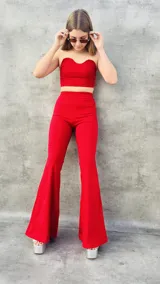 Pantalón Oxford de tiro alto, color rojo, con corte ajustado en la parte superior y acampanado en la parte inferior.