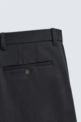 Pantalón de corte recto confeccionado en tejido compacto de algodón con estructura twill. Presenta cierre frontal con cremallera y botón, bolsillos laterales y bolsillos traseros de vivo con botón.