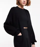 Cardigan abierto de punto pesado, con diseño alargado, mangas largas y bolsillos laterales. Confeccionado en una mezcla de viscosa, poliéster y poliamida.