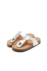 Sandalias de dedo color plateado con base de corcho y plantilla anatómica. Tienen una tira ajustable con hebilla metálica y detalle de tachas en la parte delantera.