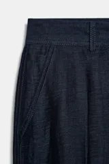 Pantalón de tiro alto color azul marino, de corte recto, con bolsillos delanteros y cierre frontal con cremallera y botón.