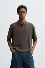 Polo de punto de corte regular fit, confeccionado en una mezcla de algodón y lyocell. Presenta cuello de solapa con cierre frontal de botones, manga corta y acabados en rib en puños y bajo.