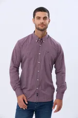 Camisa de manga larga con estampado de cuadros pequeños en tonos rojo, azul y blanco. Presenta cuello abotonado, cierre frontal con botones y un bolsillo pequeño en el pecho.