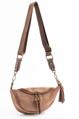 Cartera tipo bandolera de gamuza sintética color marrón, con diseño de media luna, cierre frontal con doble tirador metálico y detalle de borla lateral.