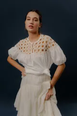 Blusa blanca de algodón con detalles de crochet en la parte superior y mangas cortas abullonadas.