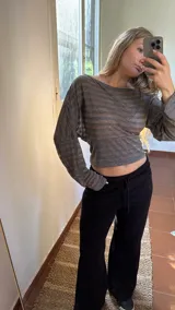 Blusa de jersey rayado con diseño de hombros caídos, mangas largas amplias y cintura ajustada.