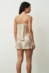Short de tiro medio en color dorado con acabado metalizado, diseño holgado y bolsillos laterales.