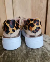 Zapatillas urbanas de cuero color beige y gris metalizado con cierre de doble velcro, detalle animal print en el talón y suela chunky blanca.