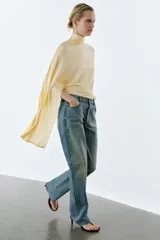 Jeans de tiro medio con corte slim y largo completo. Presentan diseño de cinco bolsillos, cierre frontal con cremallera y botón, efecto lavado y detalle de rotura en la parte delantera con bajo sin costura.