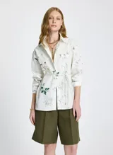 Camisa de manga larga con estampado floral y de texto, con cuello clásico, cierre frontal con botones y lazo ajustable en la cintura.