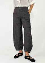 Pantalón azul marino de tiro alto y corte ancho, confeccionado en tejido con textura sutil, bolsillos laterales y cierre frontal con botón.
