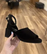 Sandalias negras de gamuza con pulsera al tobillo y taco cuadrado.