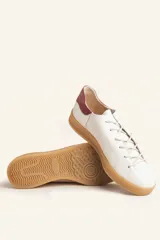 Zapatilla de cuero vacuno color azul marino, con cordones azules y suela de caucho color caramelo.