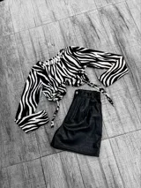 Short negro de cuero sintético con textura croco, tiro alto y corte ajustado.