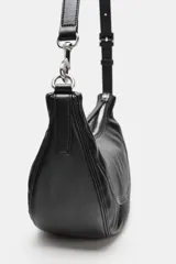 Bolso de hombro con diseño de media luna, confeccionado en material sintético con acabado texturizado. Cuenta con cierre de cremallera superior, asa ajustable con hebilla y detalle de mosquetón metálico en uno de los extremos.