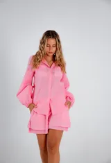 Conjunto de dos piezas compuesto por una camisa de corte relajado con mangas largas abullonadas y puños elásticos, y un short de tiro medio con cintura elástica y diseño de doble ruedo. Confeccionado en lino liviano.