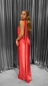 Vestido largo de satén color coral, con escote halter y espalda descubierta.