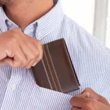 Billetera de cuero marrón claro con bordado zigzag en hilo blanco y ocre.