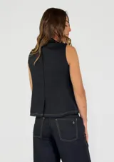 Chaleco color beige con escote en V, cierre frontal con botones y detalle de flecos en los bordes.