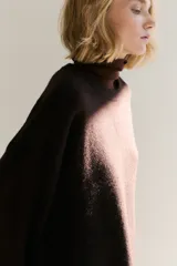 Buzo de punto suave con diseño oversized, cuello redondo acanalado y hombros caídos. Presenta terminaciones acanaladas en puños y ruedo.