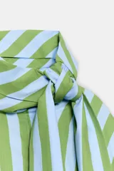 Camisa de manga larga con cuello subido y detalle de lazada frontal. Presenta un diseño de rayas verticales en tonos verde y celeste, con cierre frontal de botones y puños clásicos.