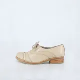 Zapato tipo Oxford de cuero color beige, con cordones y taco bajo de madera.