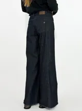 Pantalon de jean azul oscuro, de corte wide leg con botamanga deshilachada y tiro medio.