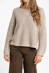 Sweater de punto texturado en color bordó con destellos de lurex, de corte holgado, cuello redondo y mangas largas.