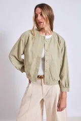 Cazadora azul de manga larga con puños elásticos, cuello redondo sin solapas y cierre frontal con botones grandes de color claro.