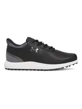 Championes de golf Under Armour, modelo Drive Medal SL, en color negro con detalles en gris y suela blanca. Presentan parte superior de microfibra, mediasuela con tecnología Charged Cushioning para amortiguación y suela exterior sin tacos para mayor flexibilidad y tracción.