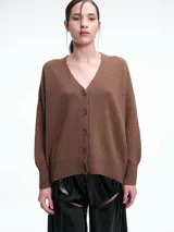 Cardigan de punto color marrón con textura jaspeada, escote en V, cierre frontal con botones y diseño de hombros caídos.
