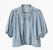 Chaqueta de denim celeste, estilo abierto con mangas 3/4 abullonadas, puños fruncidos con elástico, cuello mao y bolsillos frontales appliquéd.
