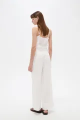 Pantalón blanco de viscosa, de corte ancho y tiro alto, con bolsillos laterales.