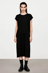 Vestido midi negro de silueta relajada, con cuello redondo y mangas cortas estilo cap.