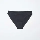 Pack de cinco braguitas de algodón, que incluye dos braguitas negras lisas, dos blancas lisas (una con estampado de lunares pequeños) y una braguita con estampado floral en blanco y negro. Todas tienen detalles de encaje en los bordes.