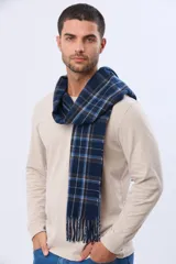 Bufanda de tejido suave con diseño de cuadros en tonos azul oscuro, blanco y marrón, con terminación de flecos en los extremos.