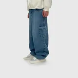 Pantalón de jean estilo cargo con corte ultra baggy, confeccionado en denim de algodón con textura rústica. Presenta bolsillos laterales tipo cargo en las piernas y un diseño holgado de tiro medio.