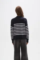 Polera de punto con diseño a rayas horizontales en contraste, cuello alto y mangas largas con puños ajustados.