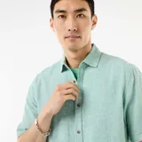 Camisa de manga corta en mezcla de lino color verde menta, con cuello camisero, cierre frontal de botones y diseño holgado.