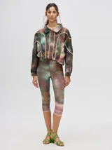 Calza deportiva 3/4 de tiro alto, confeccionada en lycra con un diseño estampado abstracto en tonos tierra, verdes y rosados.