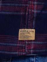 Camisa de pana color azul marino, con mangas largas, cuello clásico y dos bolsillos frontales con solapa y botón.