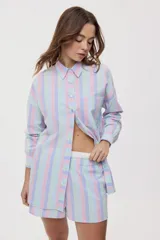 Camisa oversize de manga larga con estampado de rayas verticales en tonos rosado, celeste y verde menta. Cuenta con cuello camisero, cierre frontal con botones y un bolsillo aplicado en el pecho.