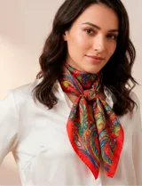 Pañuelo cuadrado de satén con estampado de arabescos en tonos rojos, azules, verdes y amarillos. Presenta un diseño clásico y versátil.