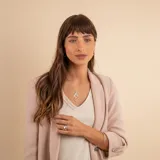 Conjunto compuesto por una cadena fina de plata 925 y un dije colgante con diseño de doble hoja estilizada, una de ellas con acabado liso y la otra con textura brillante.