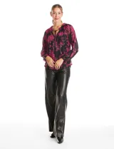 Blusa de microtul con estampado floral en tonos fucsia sobre base negra. Presenta cuello a la base con frunces, escote en V con lazo de ajuste y mangas largas con puños elastizados. Incluye forro interno a tono.