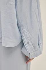 Camisa celeste de lino y viscosa, de manga larga y corte holgado.