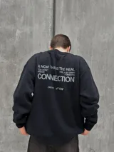 Buzo negro de corte holgado con cuello redondo y puños acanalados. Estampado frontal con la palabra "OSTEN" y la frase "NOT WHERE YOU'RE FROM A MINDSET OF BECOMING" en color blanco.