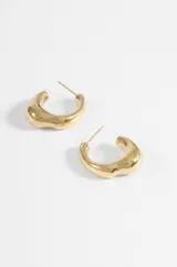 Aros de acero quirúrgico hipoalergénico, diseño de argolla gruesa con forma irregular y acabado brillante.