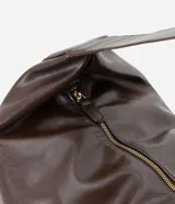 Cartera modelo hobo de gran tamaño, confeccionada en poliuretano con acabado brillante y textura suave. Presenta un diseño de media luna con asa ancha integrada para llevar al hombro y cierre superior.