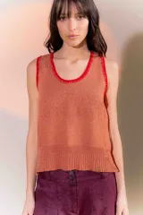 Musculosa de punto color naranja con detalles de costuras y ribetes en color rojo en el cuello y las sisas.
